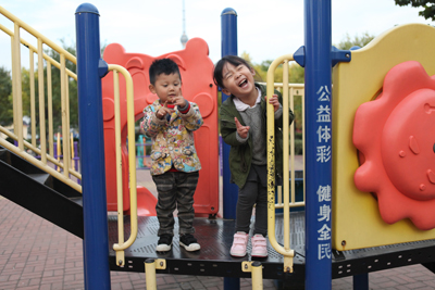 2014年10月底，两个小朋友在体彩捐建的健身器材上开心玩耍。——孙秀红.jpg